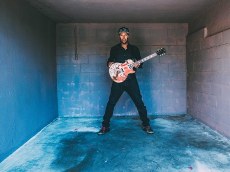 Musiker Tom Morello mit Gitarre in kleinem Raum